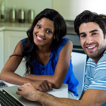 Couple looking at a computer smiling